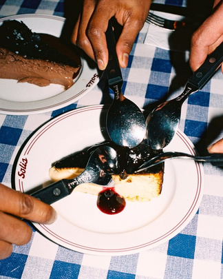 Hands serving dessert at a MEnU supper
